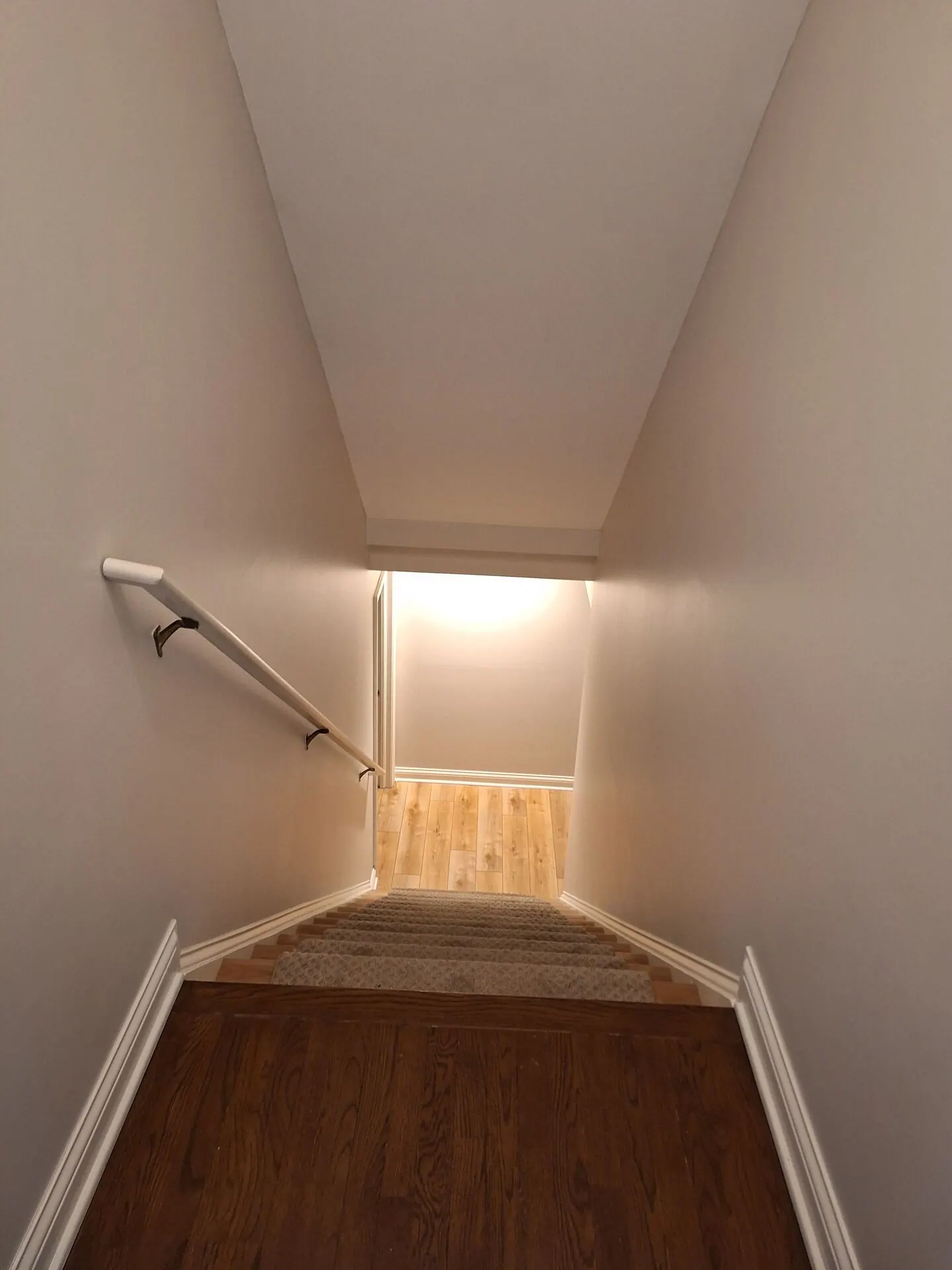 Basement stairwell painted warm beige with white trim