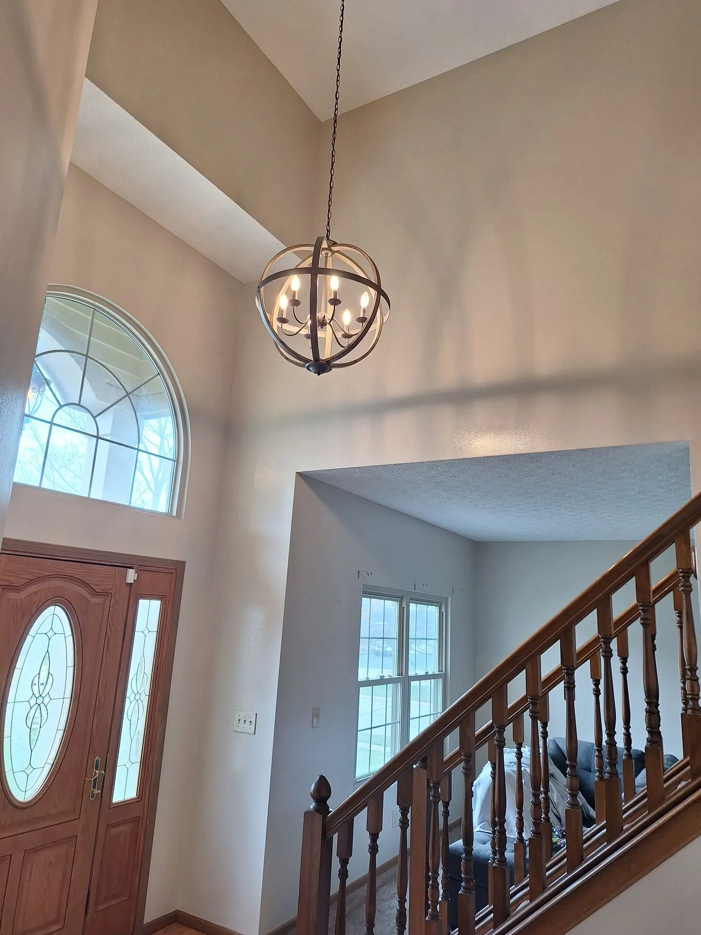 Tall foyer walls painted warm beige beside the staircase