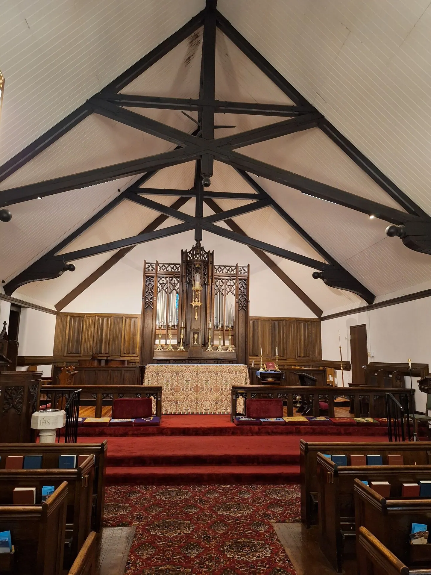 Church sanctuary with freshly painted white ceiling between black timber trusses