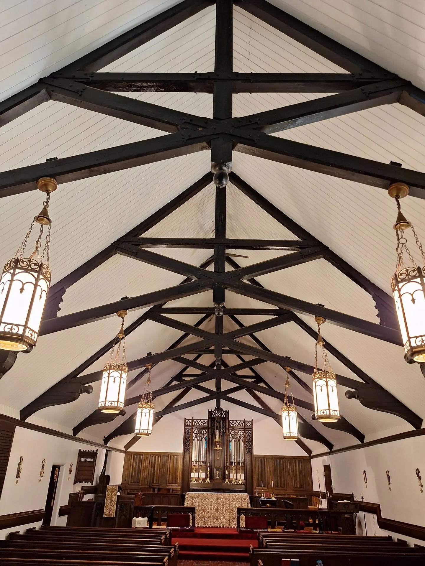 Church vaulted ceiling with dark scissor trusses and bright white walls