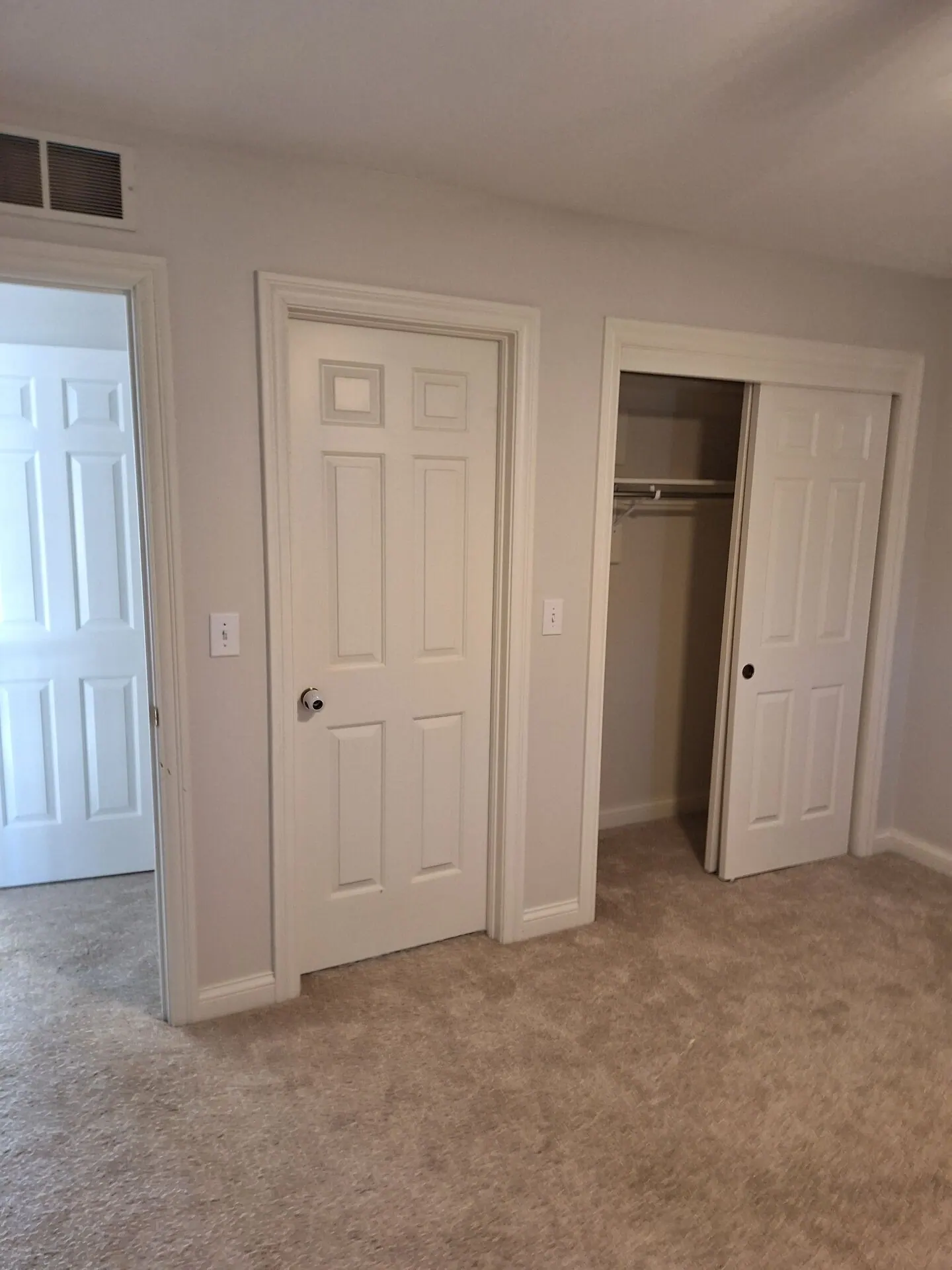 Bedroom with fresh gray walls and white six-panel doors