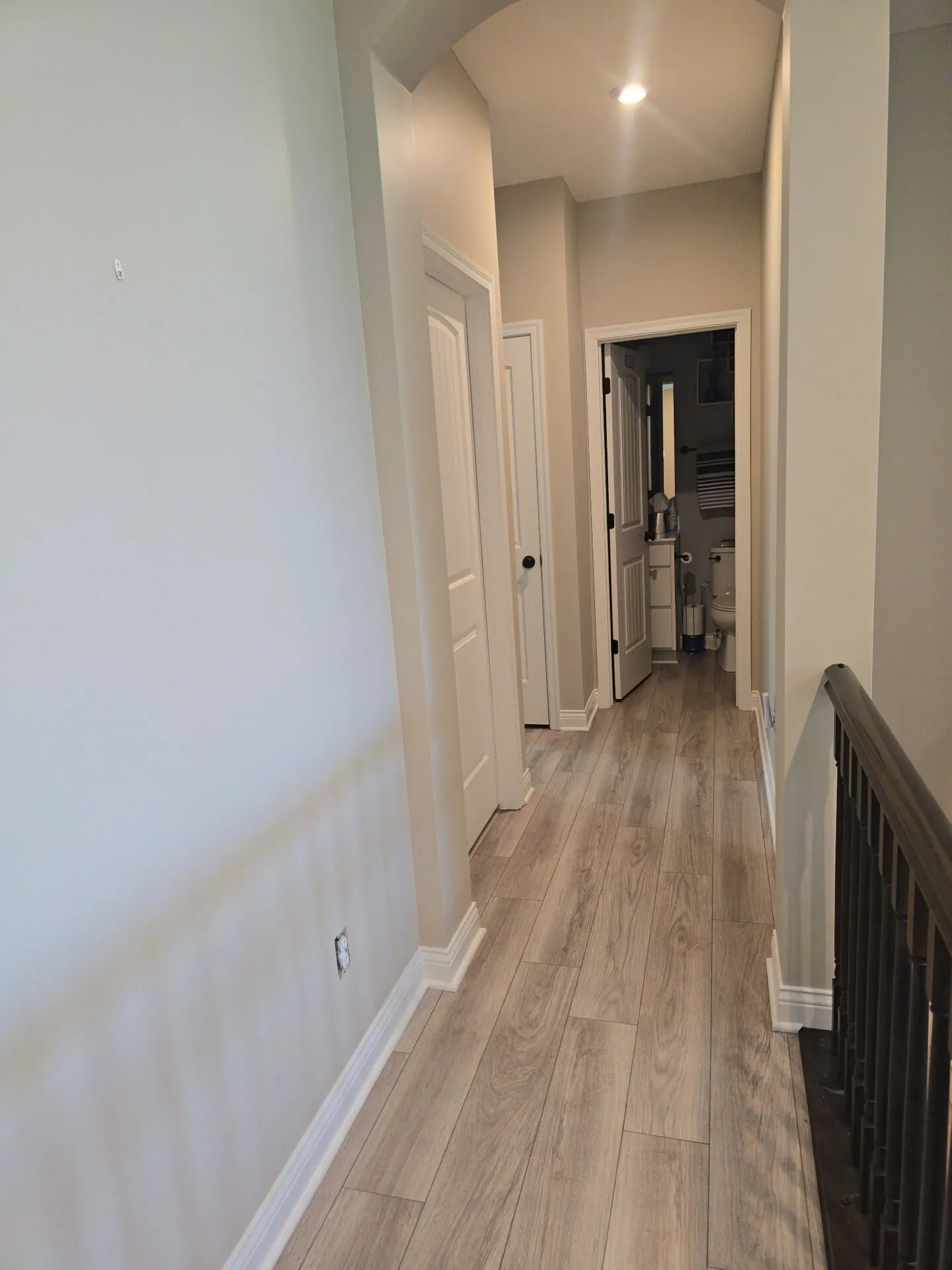 Upstairs hallway painted greige with white doors and trim