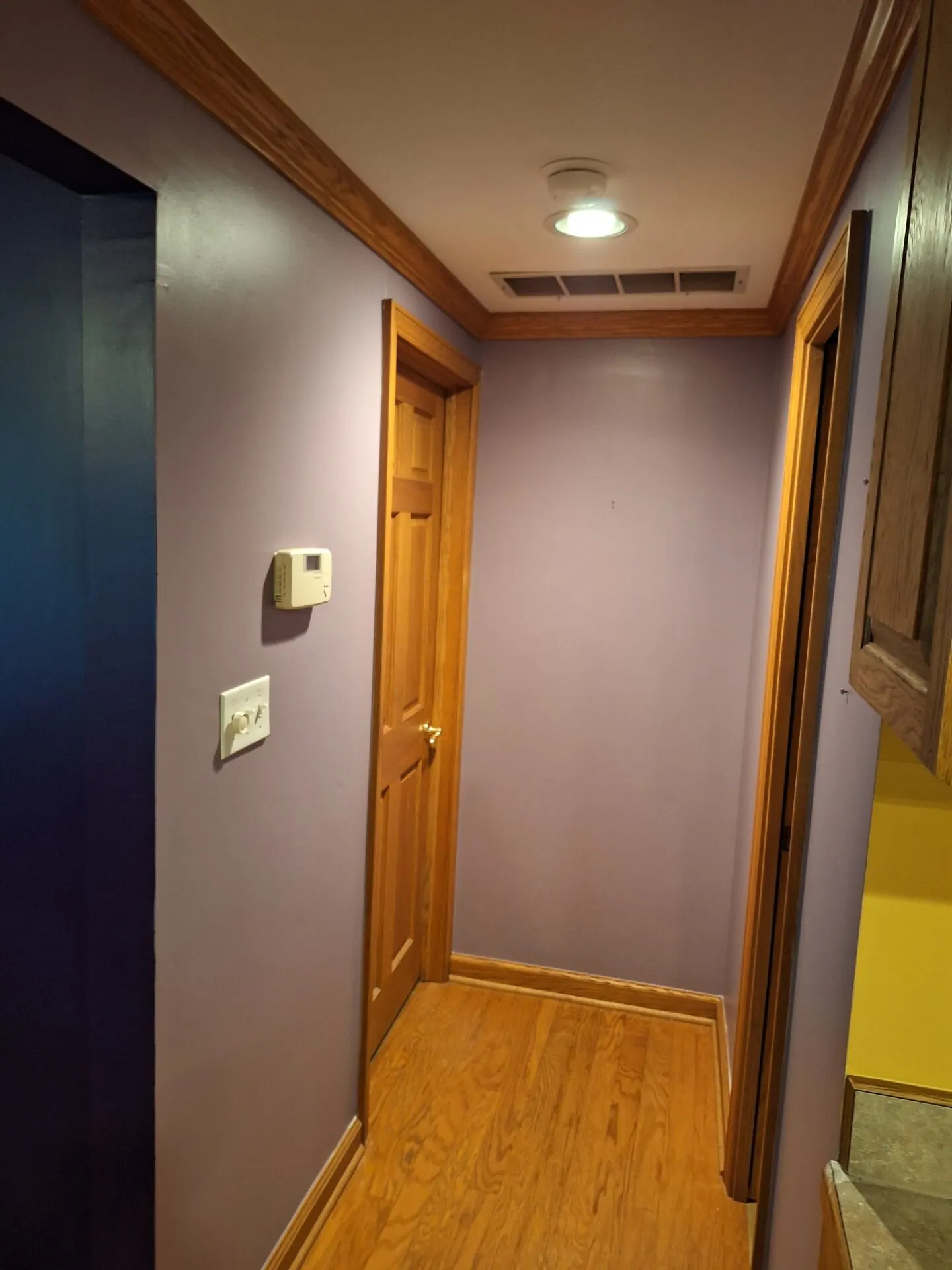 Hallway painted soft lavender gray with oak trim