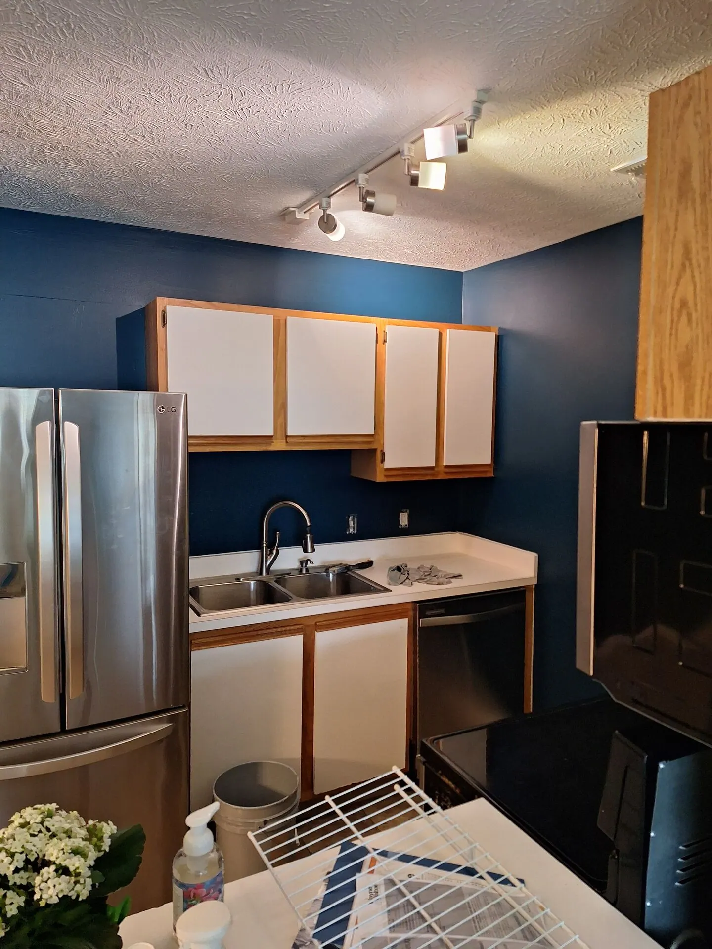 Kitchen with navy blue walls and two-tone cabinets