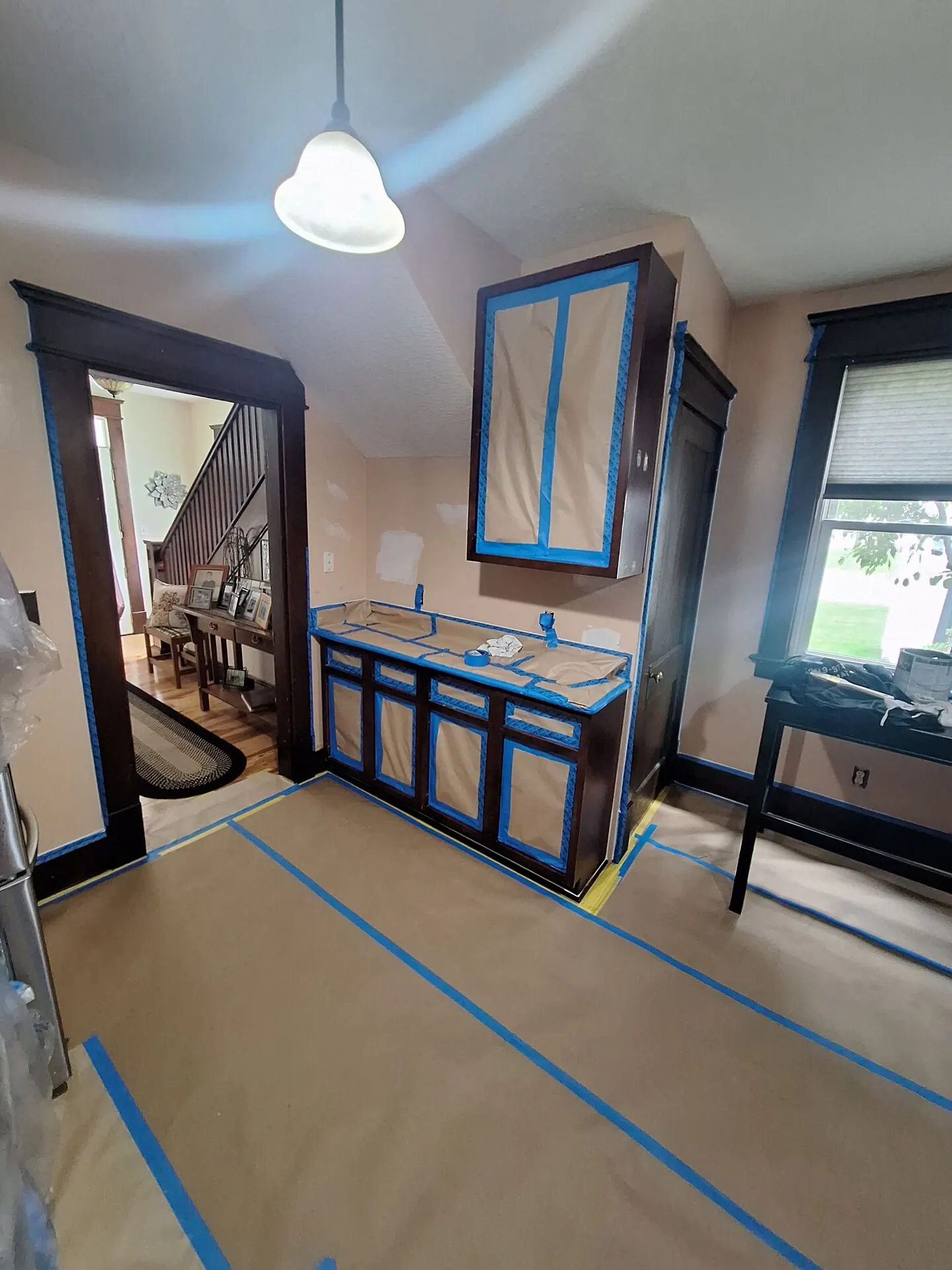 Built-in vanity painted navy with dark trim, taped and protected during refinishing