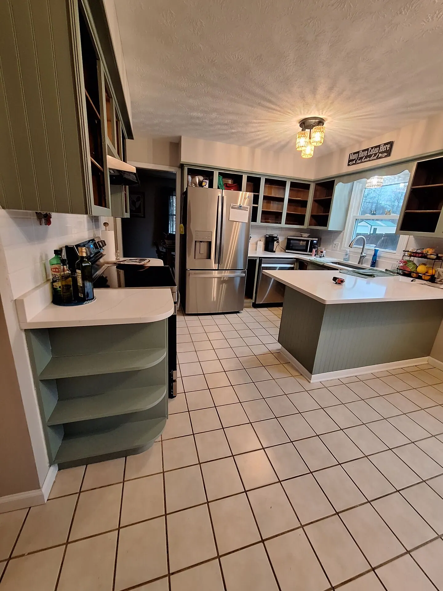 Kitchen with sage green painted cabinets and island