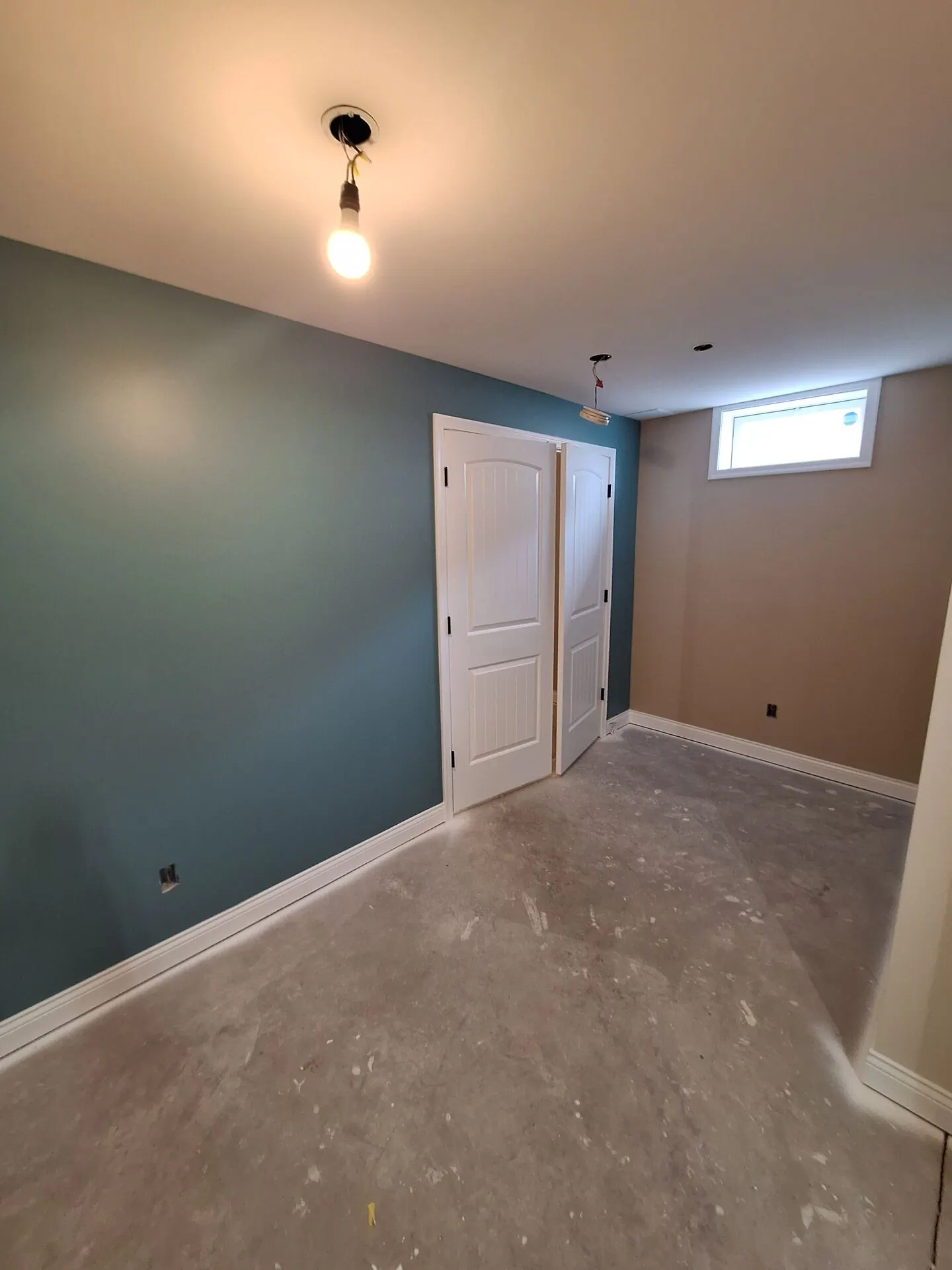Bedroom with deep teal accent wall and white doors