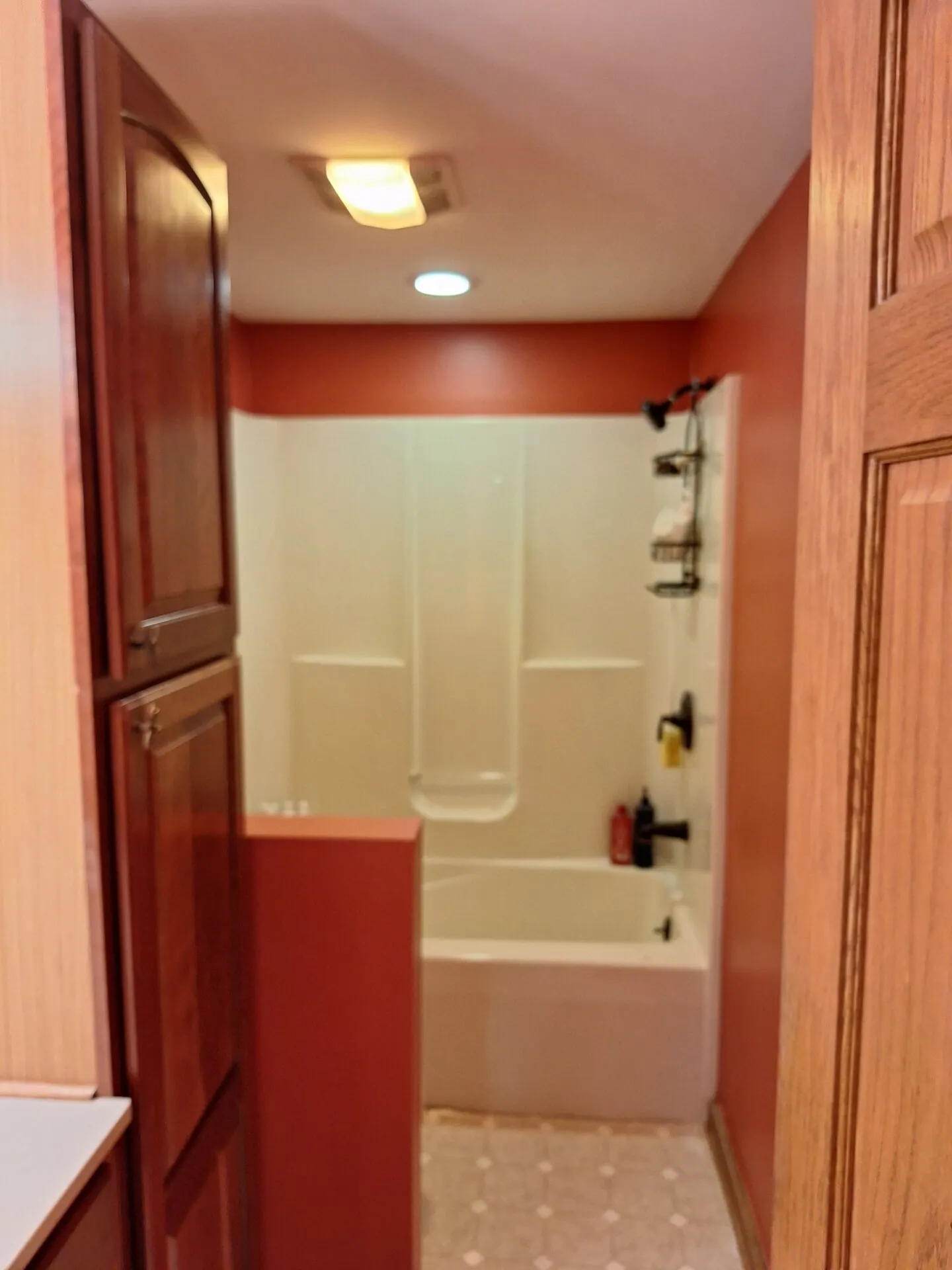 Bathroom painted terracotta red with white tub surround