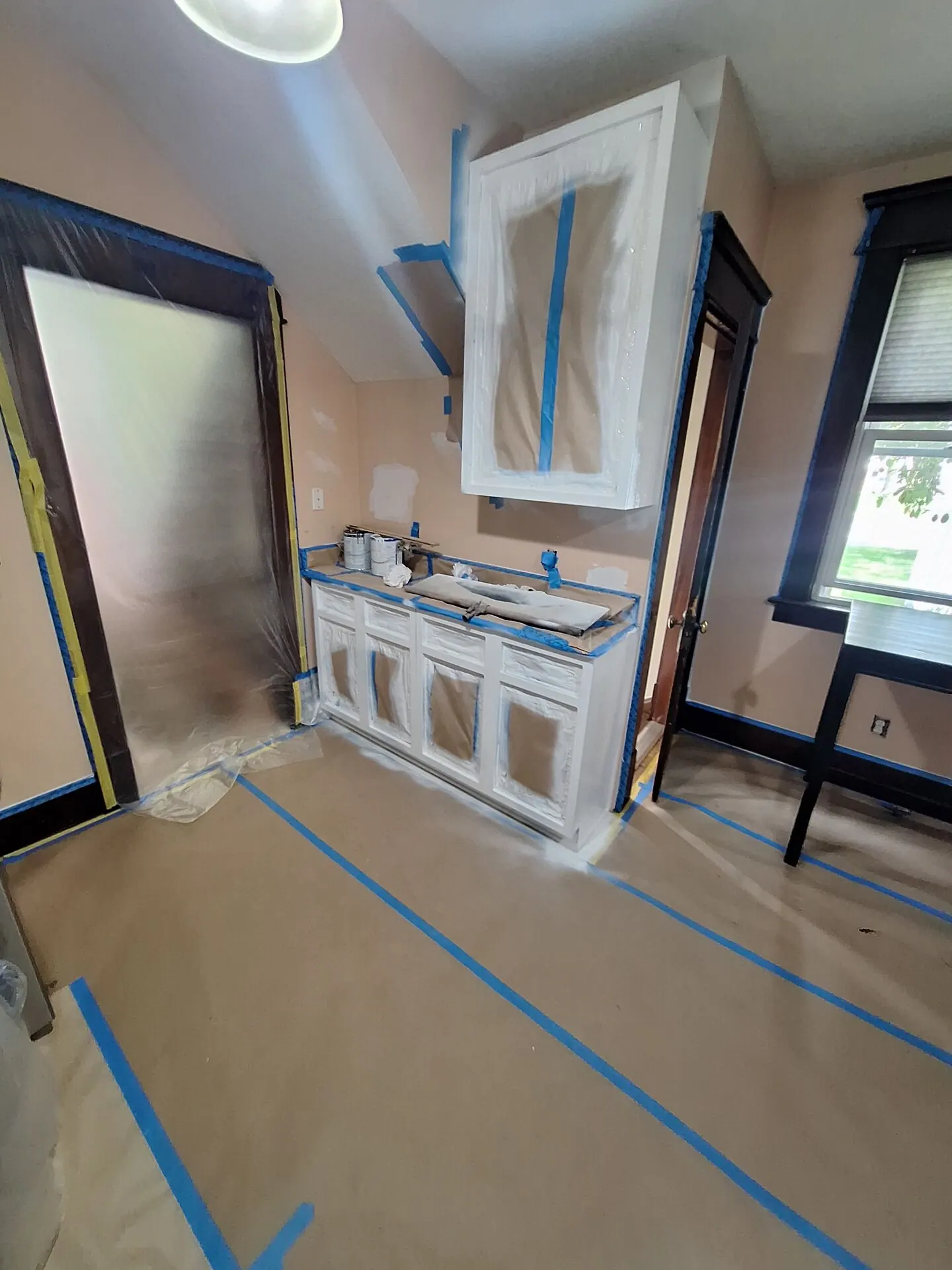 Built-in vanity and trim primed white during refinishing, floor protected