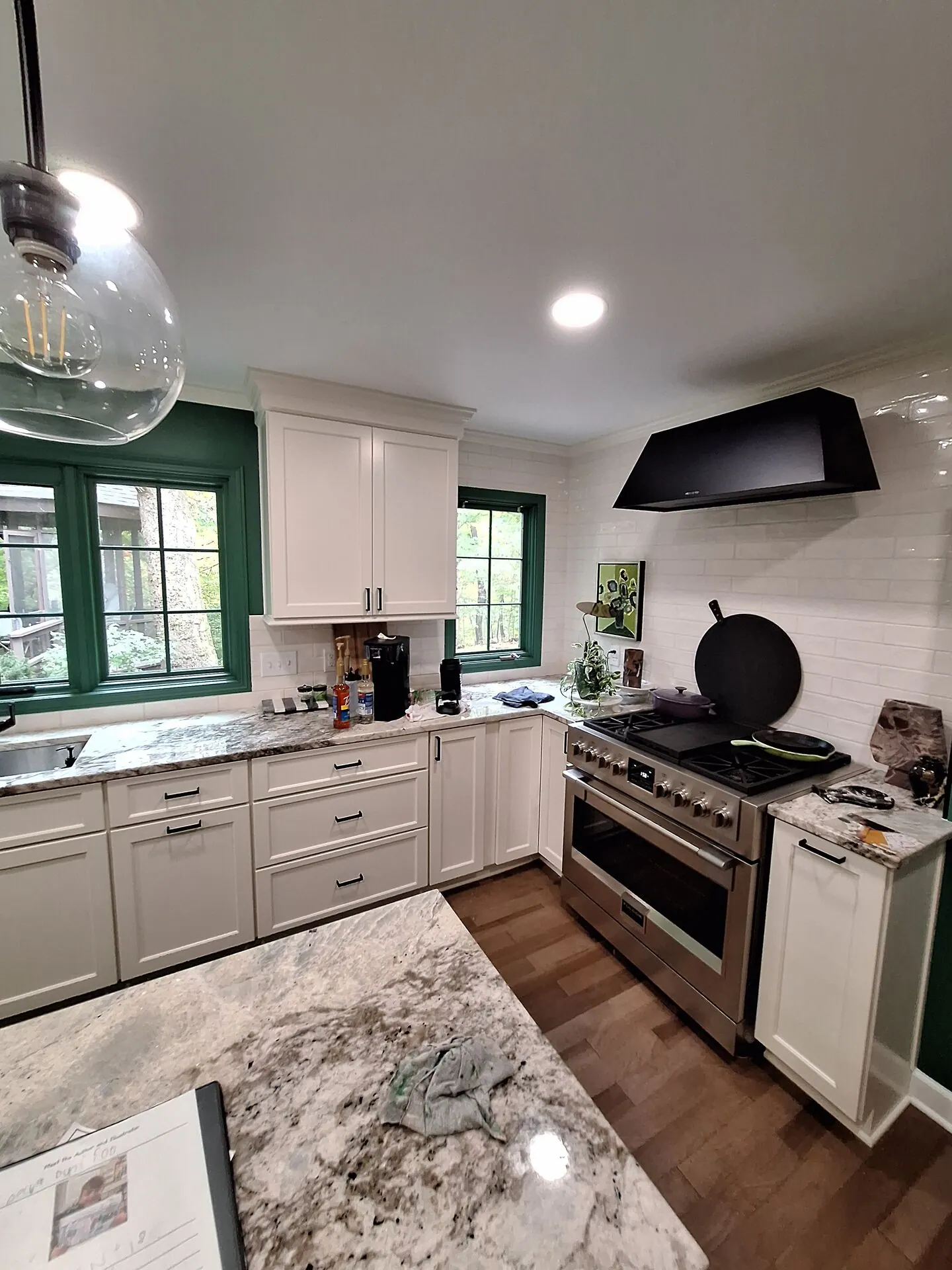 White kitchen cabinets with emerald green window trim
