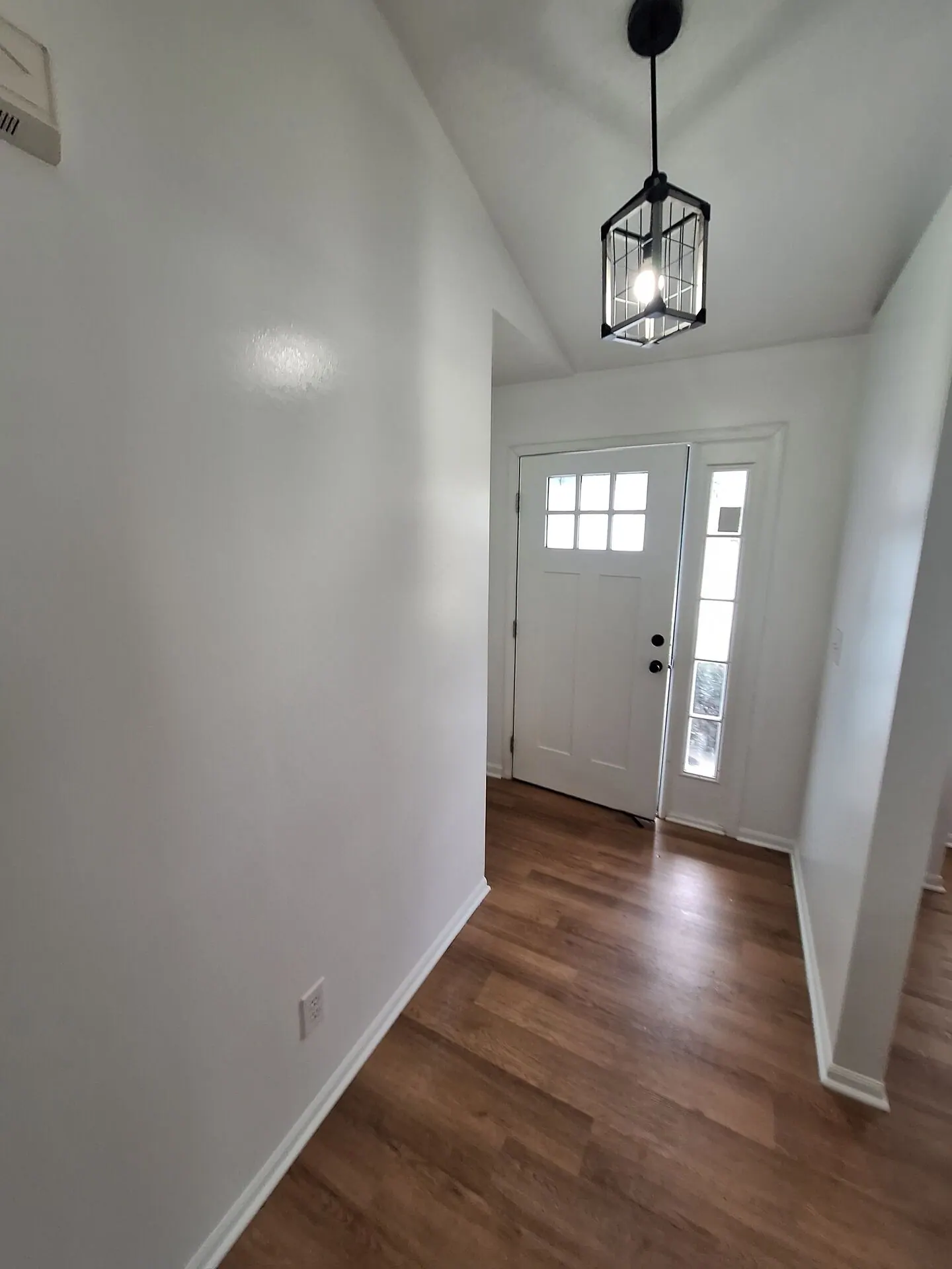 Front entry with fresh white walls and pendant light