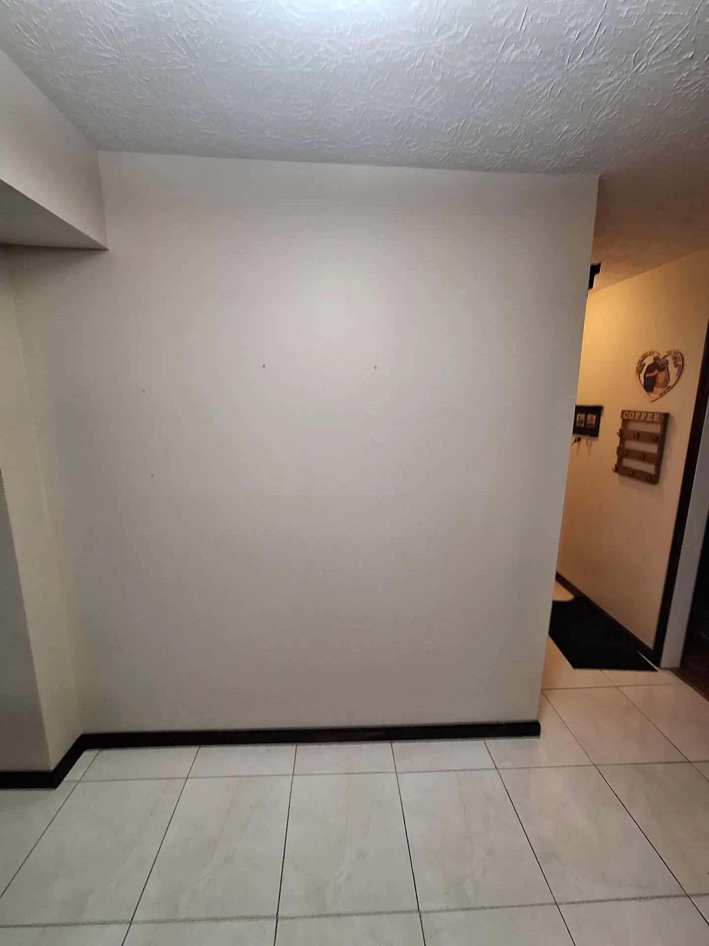 Entry wall painted fresh white above tile floor