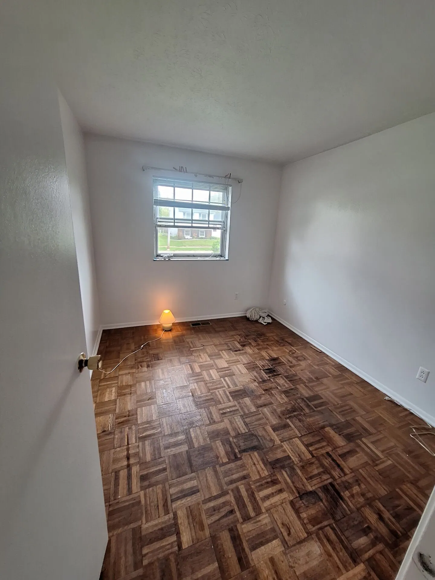 Small room freshly painted white with parquet floor