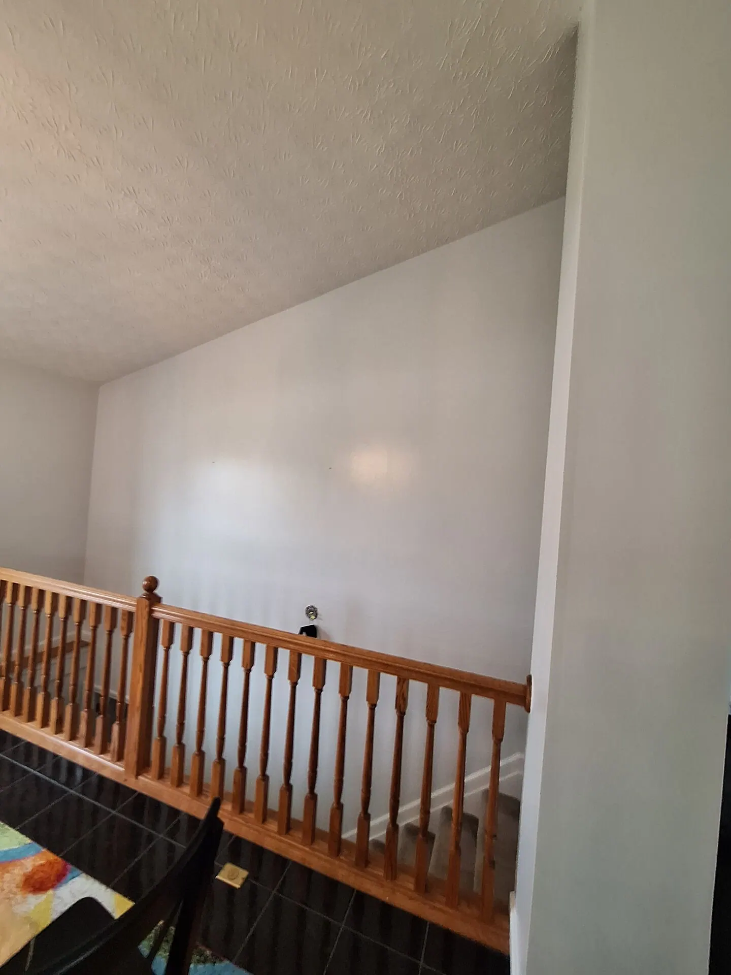Stair landing wall painted white with oak railing