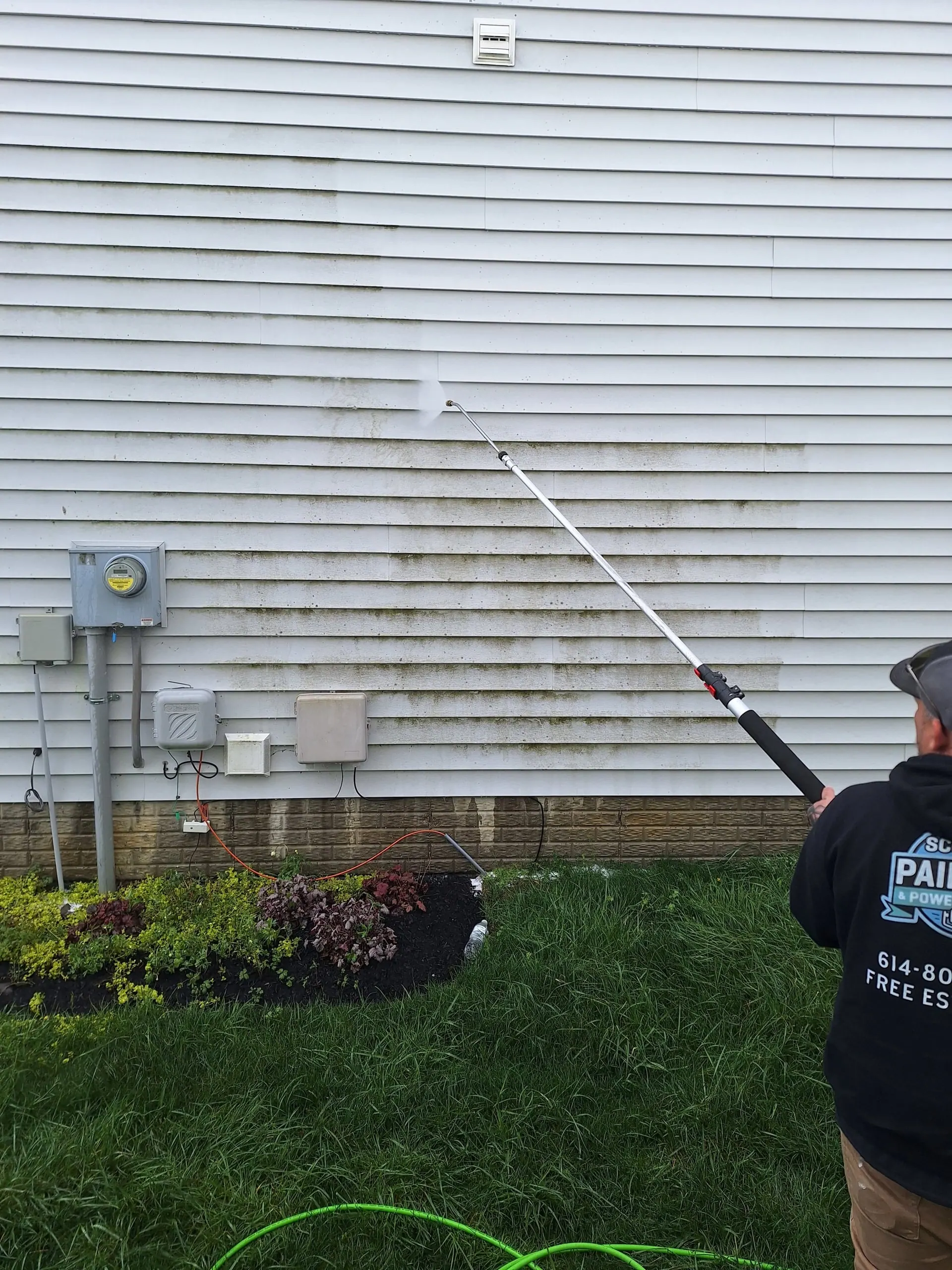 Scott's Painting crew power washing vinyl siding